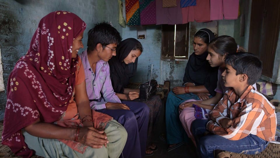 Family gathers to listen to radio, India