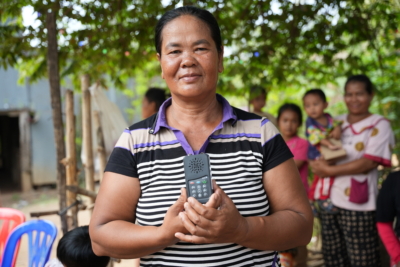 A smiling female listener holding a black portable audio Bible.