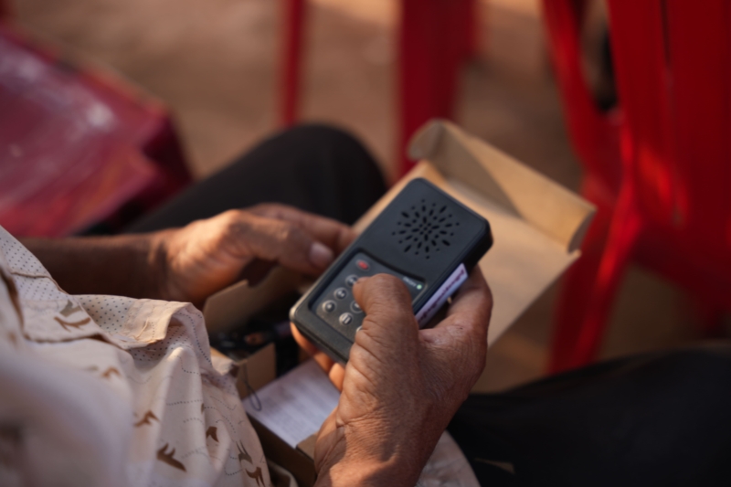A close up shot of hands holding a portable audio Bible in Cambodia.