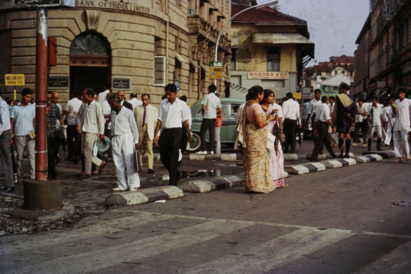 An old 1960's film photograph of a busy city street in India.