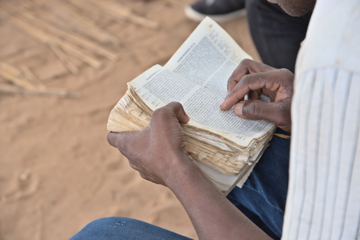 A close up of a man in Mozambique reading a Bible.