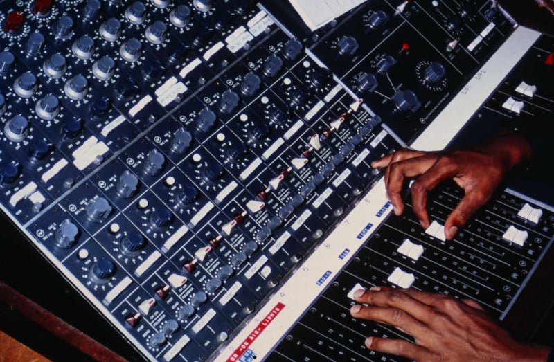 Hands operating a sound desk at the Feba radio station in the Seychelles in the 1960's.