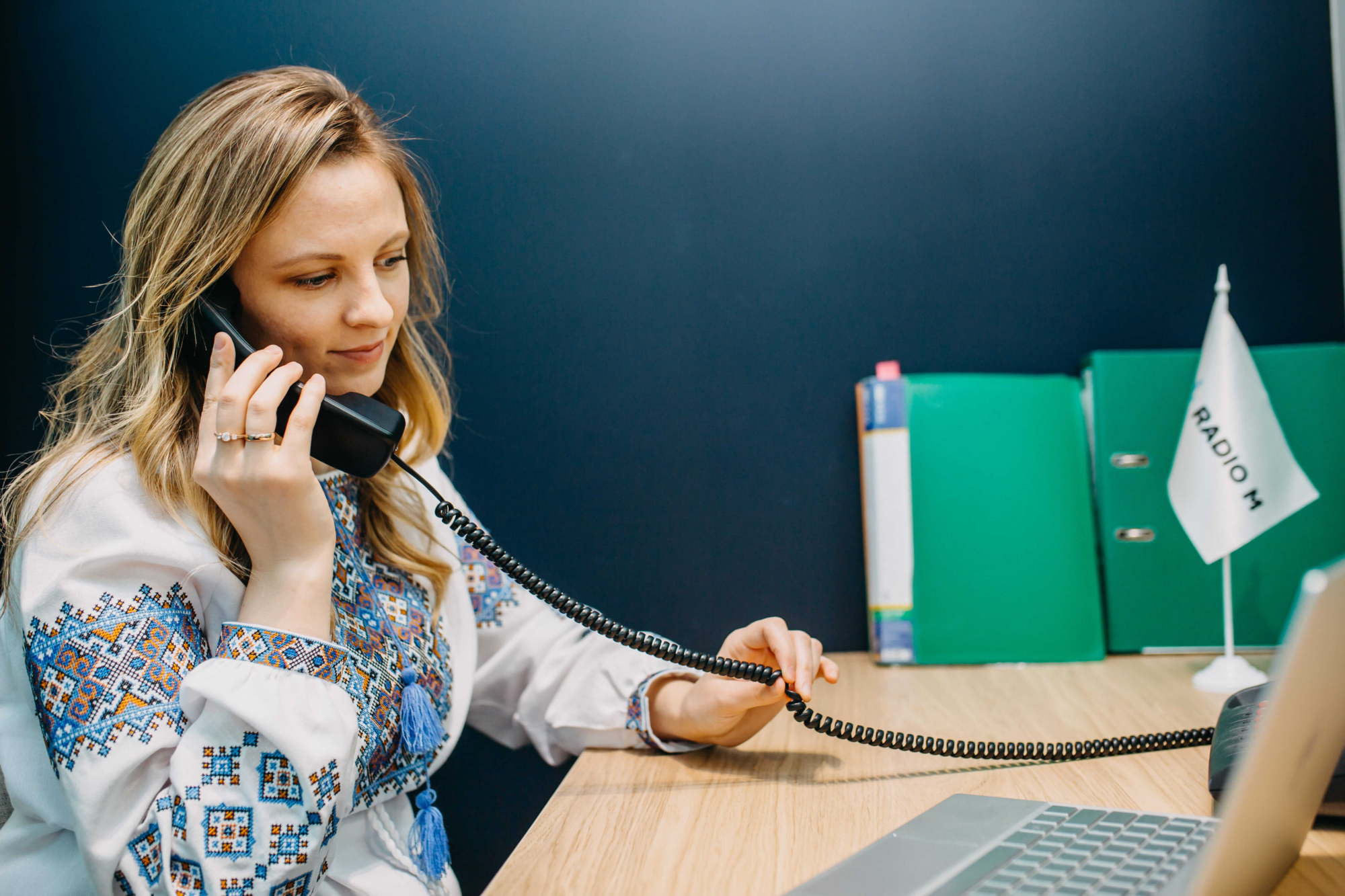 A member of the FEBC Ukraine sitting at a desk team talking on the phone.