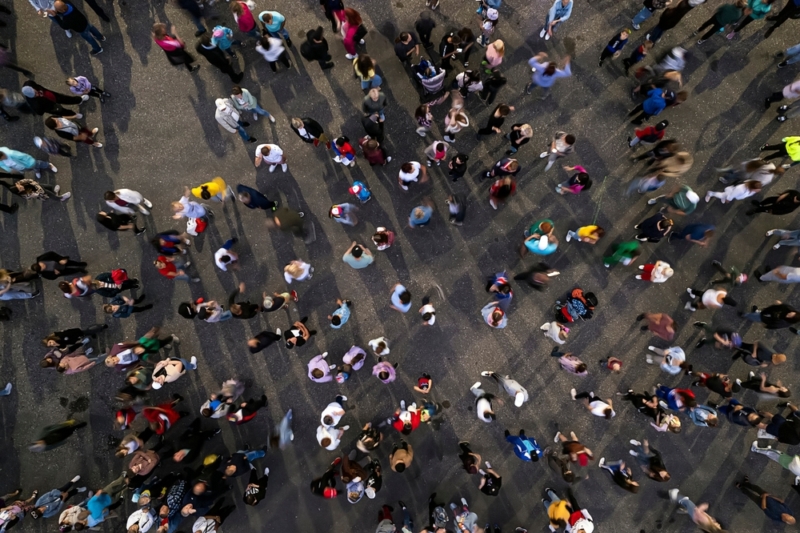 An ariel shot of a crowd of people walking across tarmac.