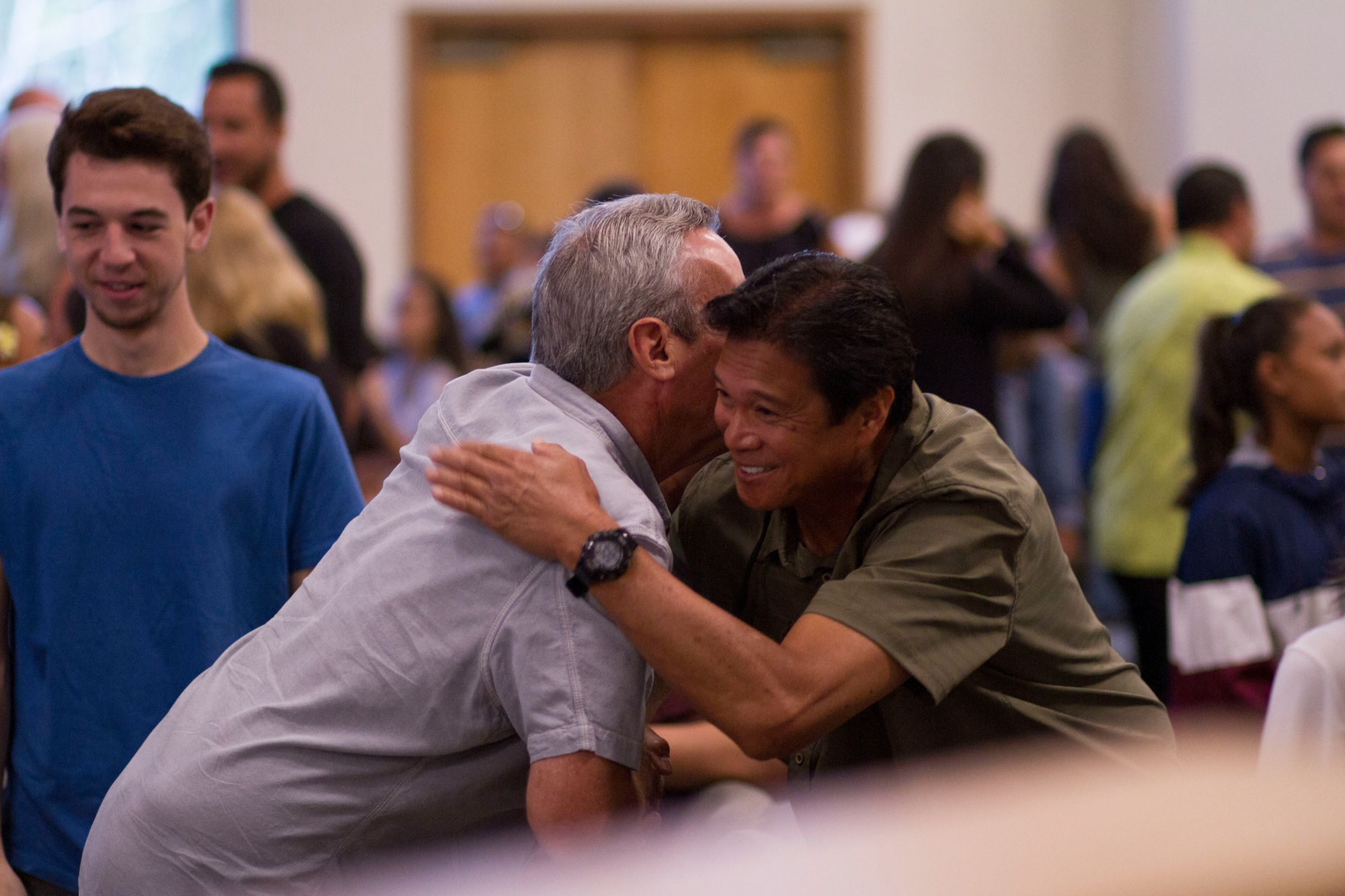 Two men hug before a church service.