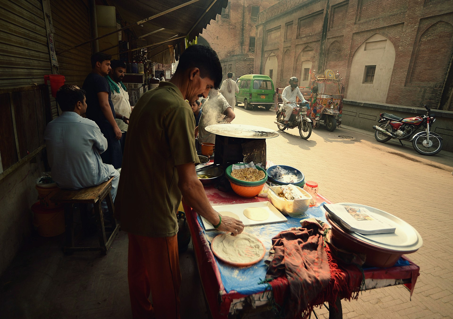 A man making chapati at a stall on a Pakistani street.