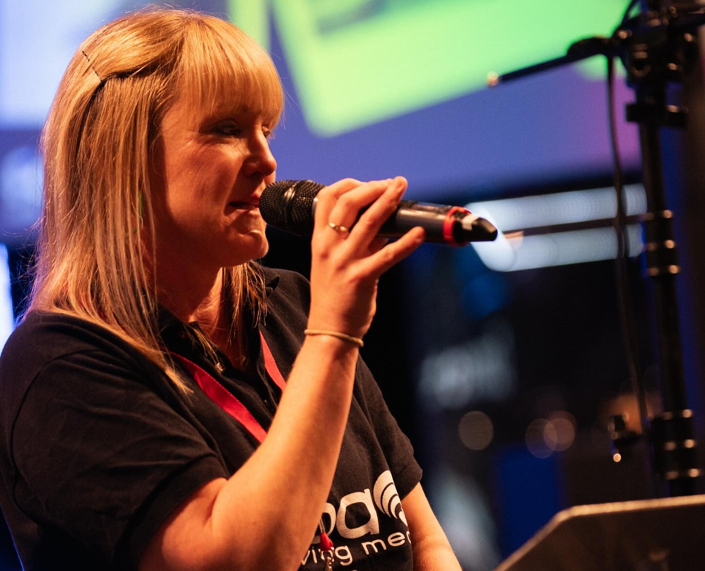 Feba staff member, Emily, speaking into a microphone at the Church Sound and Media Summit.