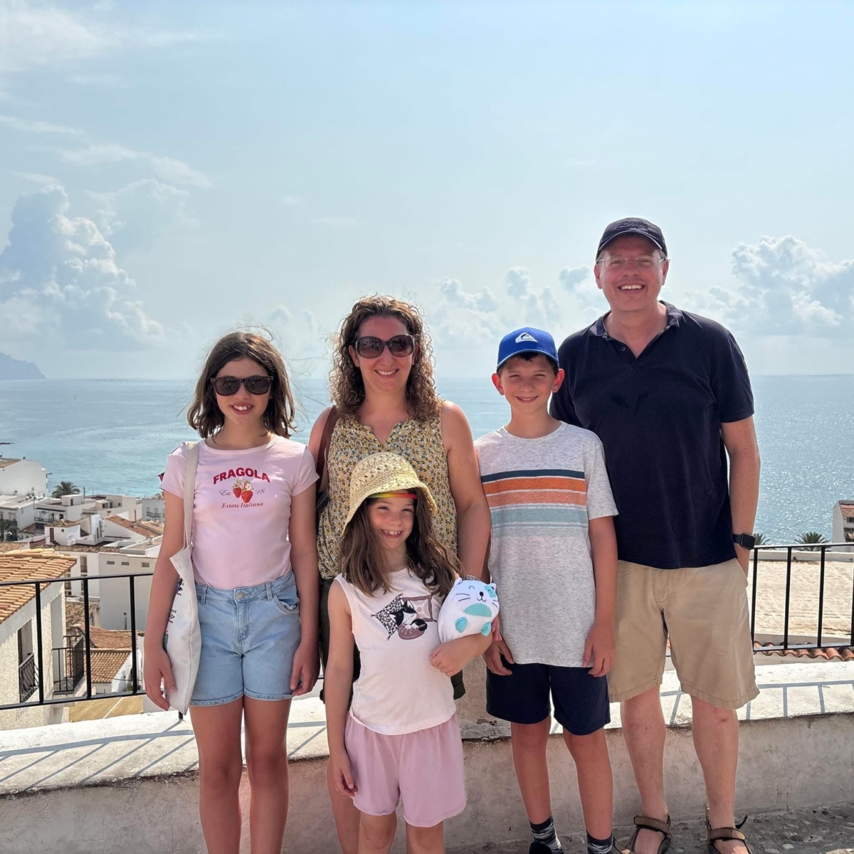 Neil, Head of International Ministry at Feba, with his wife Charlie and three young children on a balcony overlooking the sea on holiday.