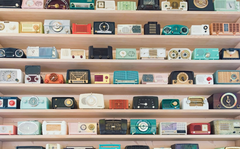 Shelves full of colourful vintage radios.