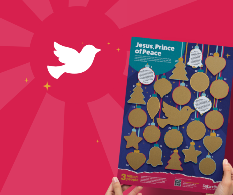 A red background with a white dove and someone holding a Feba Advent calendar overlaid on top. The calendar is A3 size and have bauble shapes that you scratch off to reveal stories. The title on the calendar reads 'Jesus, Prince of Peace'.